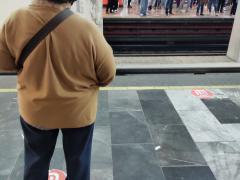 Pasajera espera a que llegue el metro. Al fondo se ven los pasajeros que van con dirección a el Rosario. En Metro Tacubaya dirección Barranca del Muerto. Fotografía tomada el 21 de junio del 2021 a las 10:17:40 2021 por Ulises Felipe Chávez Valdovinos.
