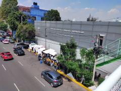 Afueras del del Hospital Regional Adolfo López Mateos del ISSSTE. Abajo se ven los puestos de comida callejera y a algunos comensales. Arriba, se lee “Clínica de Detección y Diagnóstico Automatizado” “CLIDDA ISSSTE” “Delegación Regional Zona Sur.” Fotografía  del 24 de junio del 2021 por Ulises Felipe Chávez Valdovinos.
