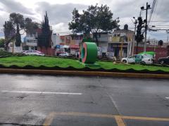 Afueras de la alcaldía Álvaro Obregón. Se observan las letras ÁO, estilo pueblo mágico. Detrás está un empleado de Lala descendiendo del camión. Trae un cubrebocas. Los negocios de los alrededores no tienen señalizaciones sobre covid19. En col. Tolteca, del. Álvaro Obregón. Fotografía del 28 de junio del 2021 por Ulises Felipe Chávez Valdovinos.