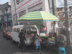 Captura de pantalla donde se observa a un policía en puesto de comida tomándose un atole se baja el cubrebocas para desayunar, en el minuto 00:02:08 del video. Av. San Jerónimo, colonia Pueblo Nuevo Alto, alcaldía La Magdalena Contreras, Ciudad de México. Video del 30 de agosto del 2021. Captura de pantalla del 10 de septiembre del 2021 por Ulises Felipe Chávez Valdovinos.