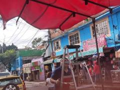 Verdulero adulto sin cubrebocas, acomoda su lona desde una escalera de aluminio, en el minuto 00:04:16 del video. Captura de pantalla del 12 de septiembre del 2021 por Ulises Felipe Chávez Valdovinos.