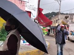 Hombre de la tercera edad con el cubrebocas mal puesto cargando botes de pintura. En cuanto ve la cámara se coloca el cubrebocas en el rostro. En el minuto 00:01:04 del video. Captura de pantalla: Ulises Felipe Chávez Valdovinos.