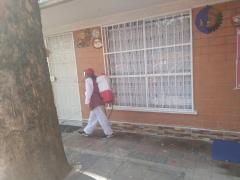 "Un elemento de la cuadrilla de sanitización de la alcaldía Gustavo A. Madero sanitizando el exterior de un departamento, se puede apreciar su equipo de trabajo". Fotografía: César Omar Rojas Gómez.