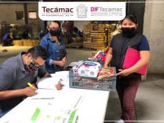 Entrega de la canasta de abarrotes a una beneficiaria.