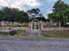 Levantamiento de cruz del difunto Filomeno León y llevada hasta el panteón de San Francisco de Asís. A la izquierda se observa algunas personas que están dentro del panteón arreglando la tumba. San Francisco de Asís, municipio Tehuitzingo, Puebla. Fotografía del 16 de septiembre del 2020 a las 6:45 de la tarde por Ulises Felipe Chávez Valdovinos.