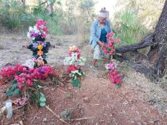 Felipa Valdovinos pone flores en la tumba de Trinidad Valdovinos. Loma Baya, municipio de Petatlán, Guerrero (tomada marzo 2021).