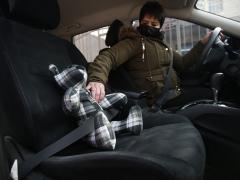 Araceli Ramírez pone el cinturón de seguridad a un oso que mandó elaborar con una camisa de su padre. Fotografía: Christian Chavez.