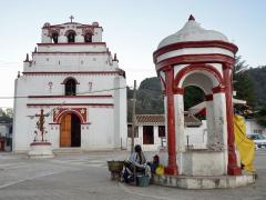 Atrio de la iglesia del pueblo con un pozo de agua al centro. Junto al pozo mujer tzental de espaldas con una olla. Fotografía: Jacobo García.