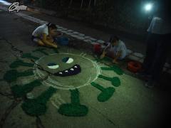 Dos niños elaboran un dibujo del símbolo del COVID-19 con aserrín. Fotografía: Tu gusto en fotografía.