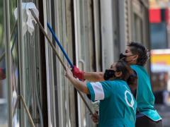 Mujeres limpian ventanales. Fotografía: Aristegui Noticias.
