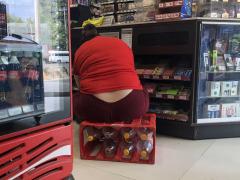 Fotografpua "Empleada de tienda de conveniencia con obesidad acomodando productos", por Dulio Rodríguez.