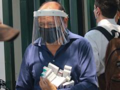 Hombre con careta, cubrebocas y medicamentos.
