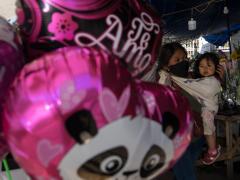 Mujer comerciante y bebe entre globos. Fotografía: Isabel Briseño.