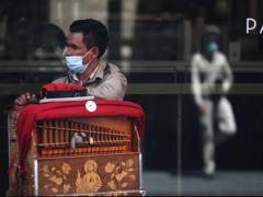 Juan Pablo, de 30 años, y de fondo su compañero Oswaldo, quien lleva un mes como organillero. Juan, en una jornada completa puede tener ingresos de 400 pesos, los cuales distribuye en comida y la renta de 100 pesos diarios del equipo. Fotografía: Karina Hernández.
