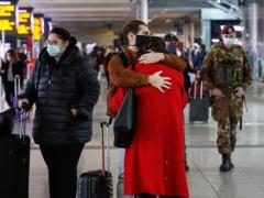 Dos personas se abrazan en lo que parece ser un aeropuerto. Fotografía: Giuseppe Lami.