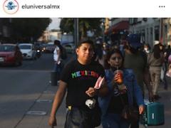 Pareja de jóvenes camina por calles del Centro Histórico. El joven no trae cubrebocas y la chica lo tiene colgando en la barbilla mientras toma una bebida. Fotografía: Carlos Solin @carlossodin89