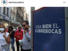 Anuncio “Usa bien el cubrebocas”; a la izquierda grupo de personas paradas. Un hombre a un costado del anuncio lleva el eubrebocas colgando sobre la barbilla. Fotografía: Carlos Solin @carlossodin89