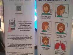 Mamparas sobre síntomas de COVID-19 en la entrada del supermercado Walmart.