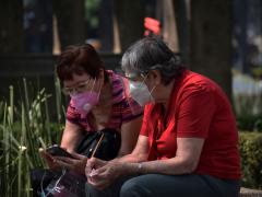Una pareja con cubrebocas observando un celular. Fotografía: Martha Patricia Leguízamo Rodea