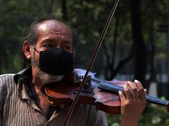 Señor con cubrebocas toca un violín. Fotografía: Martha Patricia Leguízamo Rodea