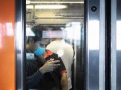 Usuario del metro con cubrebocas y celular. Fotografía: Santiago Arau.
