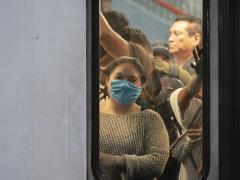 Mujer sonriente con cubrebocas dentro de vagón del metro, Línea A, metro Pantitlán. Fotografía: Santiago Arau.