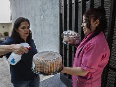 María del Carmen pide a una de las asistentes del asilo que desinfecte la comida para el festejo del Día de las Madres. Fotografía: Duilio Rodríguez.