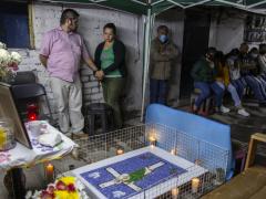 Noemi y familiares se reúnen en una celebración religiosa para rezar un novenario como forma de despedida a Cristina, quien murió por el virus. Fotografías: María Ruiz y Duilio Rodríguez.