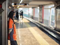Trabajadora de limpieza recargada en un letrero del Metro. Fotografía : Jesús Almazán.