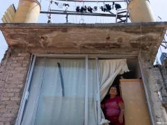 Retrato de una persona mayor mirando al cielo desde la ventana de su habitación. Fotografía: Gerardo Luna.