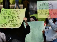 Protestantes exhiben carteles: “No quiero contagiar a mi familia, agilicen vacunación”, “AMLO, exigimos que se agilice el proceso de vacunación”, CdMx. Fotografía: Haarón Álvarez.