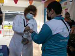 Trabajadora del personal sanitario aplica gel antibacterial en las manos de un estudiante. Fotografía: Alexa Herrera.