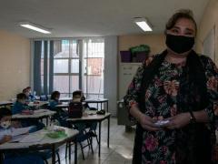 Retrato de una profesora que está feliz de comenzar las clases presenciales con los alumnos de primaria. Fotografía: Alexa Herrera.