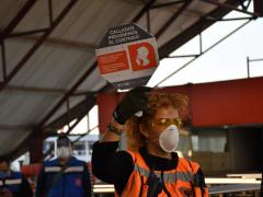 Vigilanta del Metro exhibe paletón del cartel “Callados prevenimos el contagio” a pasajeros del Metro de la CdMx.