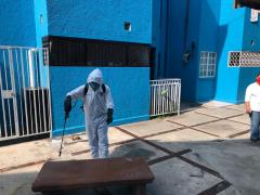 Brigadista sanitiza una mesa en la Unidad Habitacional. Fotografía: Facebook Territorial Santa Cruz-Quetzalcóatl Alcaldía Iztapalapa.