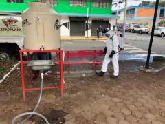 Brigadista sanitiza la banca de un espacio público de la colonia. Fotografía: Facebook Territorial Santa Cruz-Quetzalcóatl Alcaldía Iztapalapa.