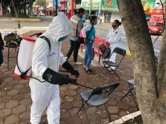 Brigadista sanitiza  asientos utilizados en el espacio público. Fotografía: Facebook Territorial Santa Cruz-Quetzalcóatl Alcaldía Iztapalapa.