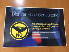 Póster a color informa a los pacientes que no se les podrá saludar de mano, consultorio  Hospital Ángeles Metropolitano. Fotografía: Gloria Elisa Melgarejo García.