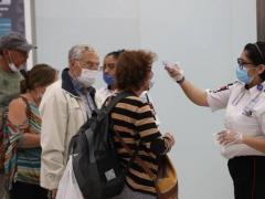 En el aeropuerto de la Ciudad de México, personal de seguridad registra la temperatura a pasajeros,como parte de la medidas de prevención contra el coronavirus.