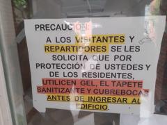 Letrero Precaución a los visitantes y repartidos, Villa Olímpica, CdMx. Fotografía: Amanda Isabel Rivera Omaña.
