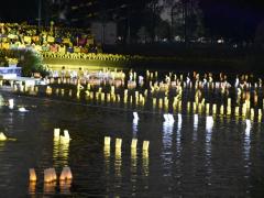 Fotografía de velas encendidas flotando en el lago artificial de la Utopía Ollini, alcaldía Iztapalapa.