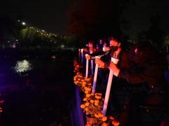 Fotografía de personas encendiendo veladoras en homenaje, alcaldía Iztapalapa.