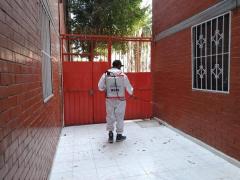 Brigadista sanitiza pasillo de la entrada, Unidad Habitacional Cabeza de Juárez I. Fotografía: Facebook Alcaldía Iztapalapa.
