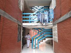 Brigadista sanitiza pasillo y escaleras, Unidad Habitacional Cabeza de Juárez I. Fotografía: Facebook Alcaldía Iztapalapa.