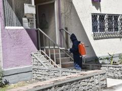 Integrante de la brigada sanitizando escaleras de una vivienda, Iztapalapa.