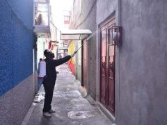 Hombre sanitiza la puerta de una vivienda. Fotografía: Facebook Alcaldía Iztapalapa.