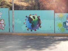 Mural que representa al mundo como un virión del SARS-CoV-2, muros de contención del Parque Ecológico “El Cantil” y Centro de Reacción Inmediata "El Cantil", colonia Candelaria Ticomán, alcaldía Gustavo A. Madero. Fotografía: César Omar Rojas Gómez.