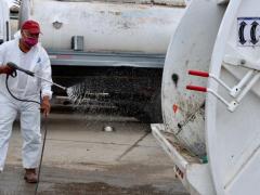 Hombre desinfecta camión de basura. Fotografía: Factor de Cambio.