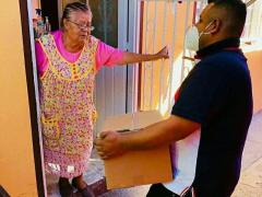 Señora de la tercera edad recibe una despensa en su casa y la recibe sin protección. Fotografía: Instagram Cuautitlán comunidad.