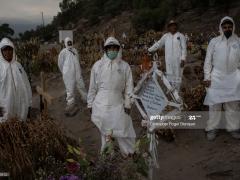 Fotografía de cinco trabajadores con trajes de protección en panteón.